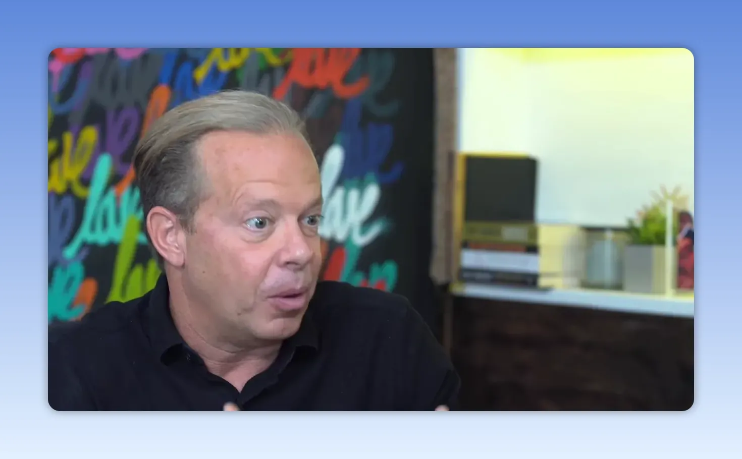 Intervenant parlant avec expression animée et gestes visibles, fond coloré