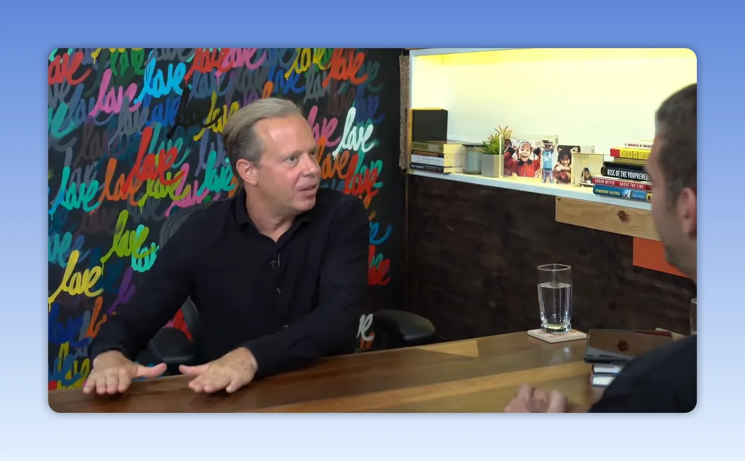 Intervenant gesticulant légèrement avec la main posée sur la table durant une interview