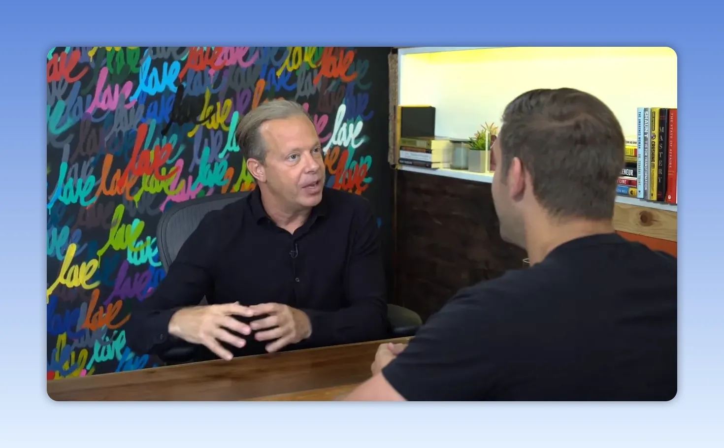 Intervenant utilisant des gestes de main pour illustrer un concept de visualisation pendant un entretien, interlocuteur vu de dos.